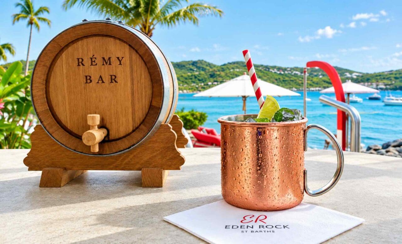 Copper mule cocktail at Eden Rock St Barths with a Rémy Bar barrel overlooking a tropical beach.
